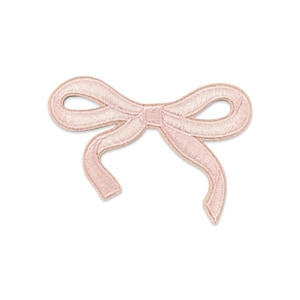 May include: A light pink embroidered patch in the shape of a bow. The patch features a satin-like thread finish with a central knot and two trailing ribbon ends, showcasing a detailed stitched border that defines the overall bow silhouette.