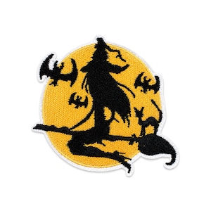 May include: A circular embroidered patch featuring a black silhouette of a witch riding a broomstick against a bright yellow full moon. The design includes small black silhouettes of flying bats and a cat with an arched back on the broom handle.