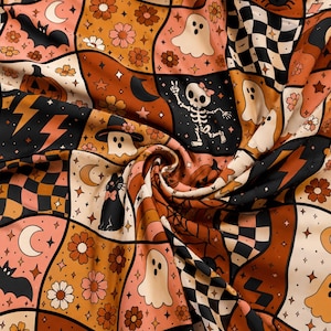 May include: A fabric featuring a repeating grid pattern with Halloween-themed illustrations including ghosts, skeletons, pumpkins, black cats, bats, flowers, moons, stars, and checkered squares in a color palette of orange, black, pink, and cream.