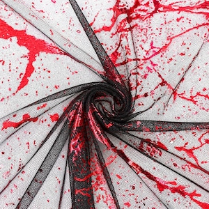 May include: Black mesh fabric with red splatter design. The fabric is folded and swirled, showcasing the texture and pattern. The red splatters vary in size and shape, creating a dramatic effect. The fabric is likely used for costumes or themed decor.