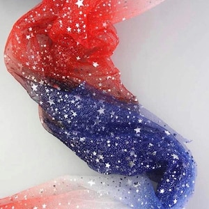 May include: A flowing fabric with a gradient of red, white, and blue, adorned with silver star-shaped sequins. The material is layered and appears lightweight, creating a festive and patriotic aesthetic. Ideal for crafting or decorative purposes.