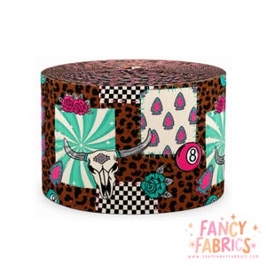 May include: A roll of ribbon featuring a patchwork design with brown leopard print, black and white checkerboard squares, turquoise sunbursts, pink roses, teal roses, pink arrowheads, a white cow skull, and a pink number eight billiard ball.