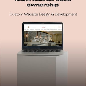Puede incluir: Un portátil que muestra un sitio web con el texto "STAY AT OUR LUXURY HOTEL IN HYDERABAD PAKISTAN". La pantalla está colocada sobre un cubo blanco contra un fondo rosa claro. El texto "100% source code ownership" y "Custom Website Design & Development" están en la parte superior.
