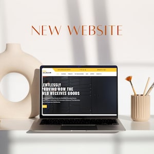 K&ouml;nnte beinhalten: Ein Laptop, der eine Website mit dem Text "NEW WEBSITE" in brauner Schrift anzeigt. Die Website hat ein schwarz-gelbes Farbschema und den Text "Endlessly Proving How The RLD Receives Goods."