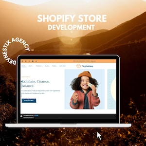 May include: A laptop screen showing a website for "Tinybabies" with the text "Exfoliate, Cleanse, Balance." The website features a child holding a product. The background includes a mountain scene and the text "SHOPIFY STORE DEVELOPMENT."
