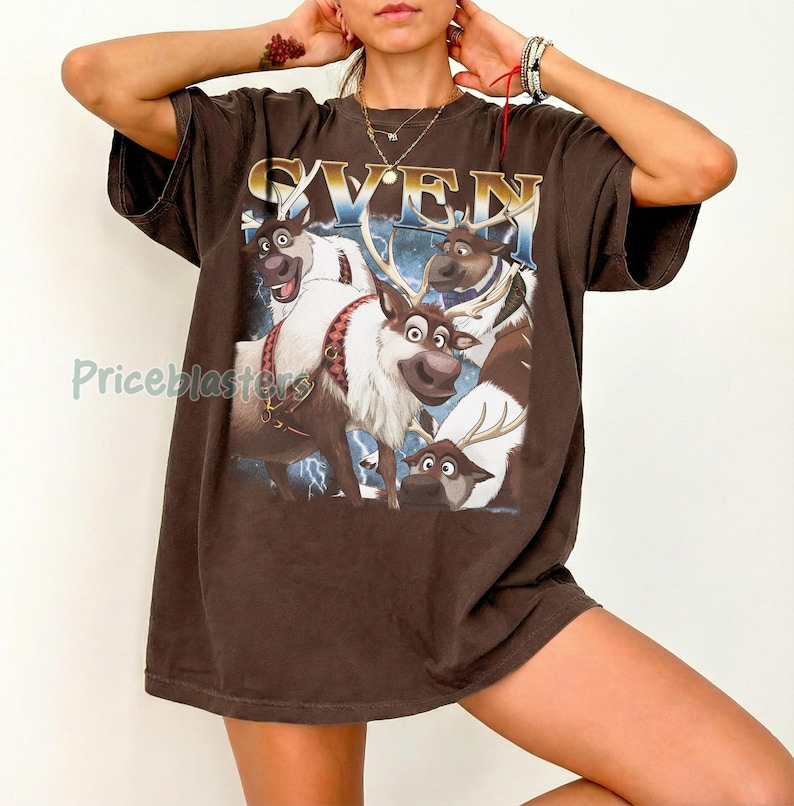 May include: Brown t-shirt featuring a graphic of Sven from the movie Frozen. The design includes the word "SVEN" in gold lettering above an illustration of the reindeer character. The shirt has short sleeves and a relaxed fit.
