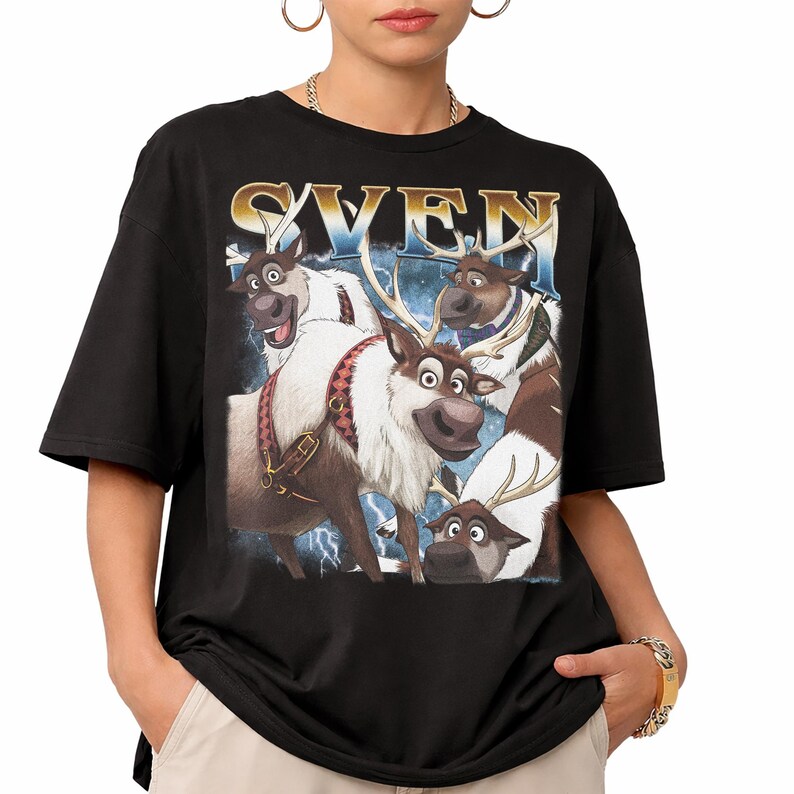 May include: Black t-shirt featuring a graphic of the reindeer Sven from the movie Frozen. The graphic includes the word "SVEN" in a gold and blue font, with images of Sven and other reindeer characters. The shirt has short sleeves.