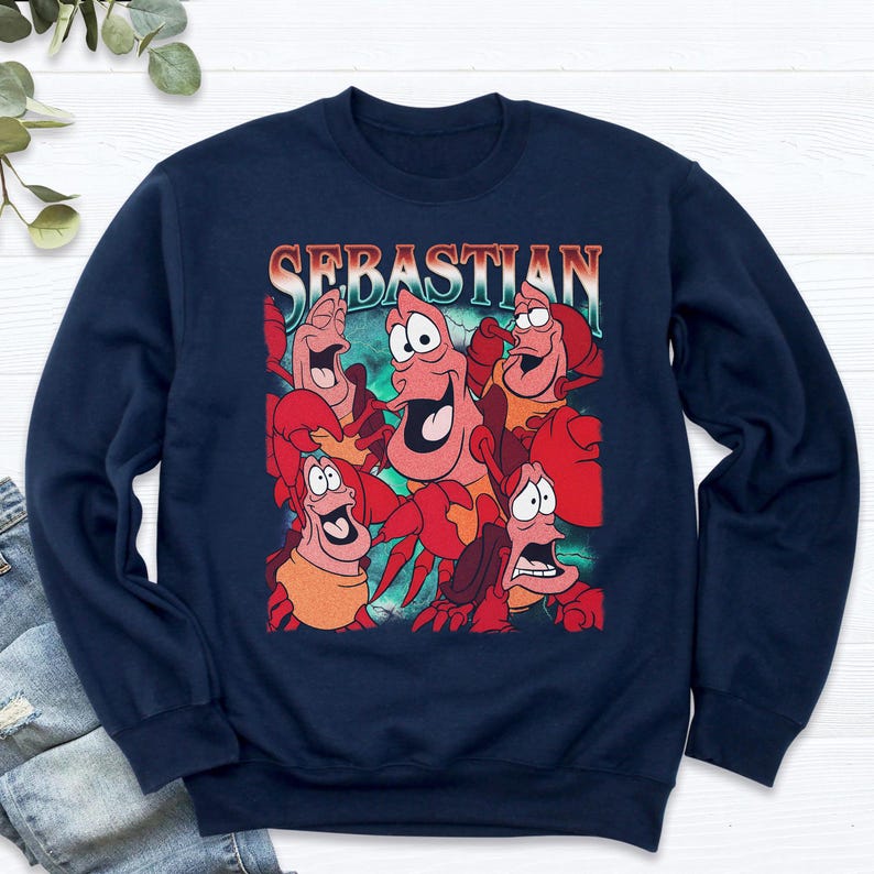 Pu&ograve; includere: Felpa blu navy con una grafica di Sebastian il granchio de La Sirenetta. Il design include pi&ugrave; immagini di Sebastian con la scritta "Sebastian" sopra. La felpa &egrave; uno stile girocollo.