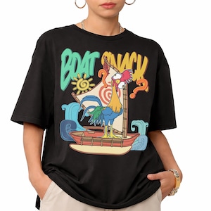 Puede incluir: Camiseta negra con un gallo de dibujos animados en un barco con el texto "BOAT SNACK". El gallo es amarillo, azul y rojo, con una expresi&oacute;n confusa. El dise&ntilde;o incluye olas, un sol y signos de interrogaci&oacute;n.
