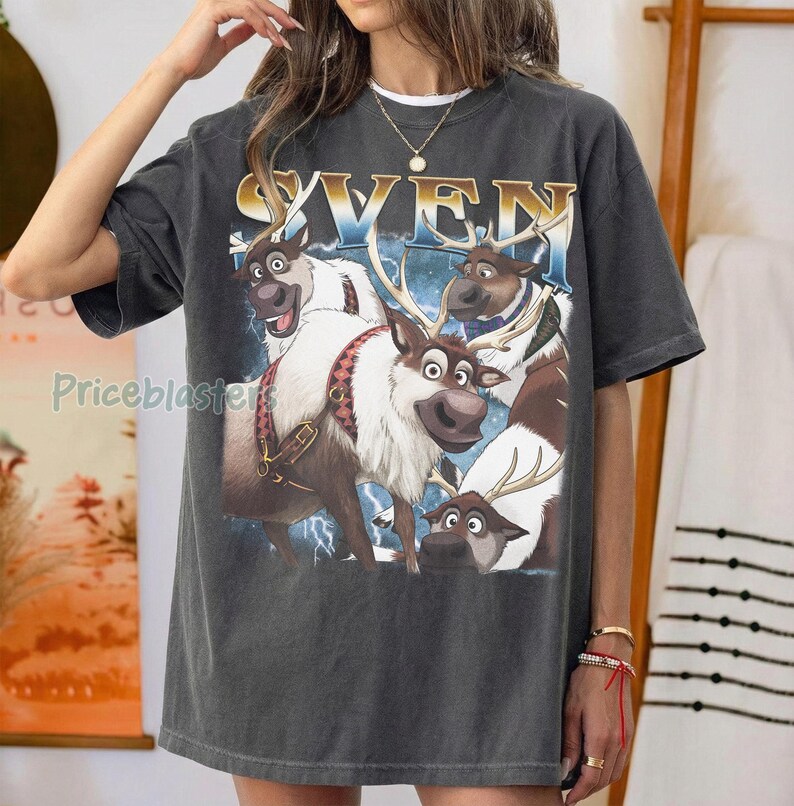 May include: Dark gray t-shirt featuring a graphic of four reindeer with the word "SVEN" in gold and blue. The reindeer have brown and white fur, and some have antlers. The shirt has a vintage, worn look.
