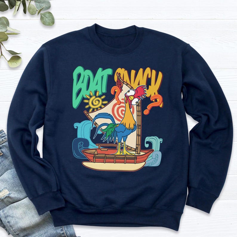 Puede incluir: Sudadera azul marino con un gallo de dibujos animados en un barco y el texto "BOAT SNACK". El dise&ntilde;o incluye un sol, olas y un signo de interrogaci&oacute;n. El gallo tiene plumas rojas, amarillas y azules.