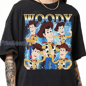May include: Dark gray t-shirt featuring a graphic of Woody from Toy Story. The design includes multiple Woody illustrations with a blue and white lightning background and the word "WOODY" at the top.