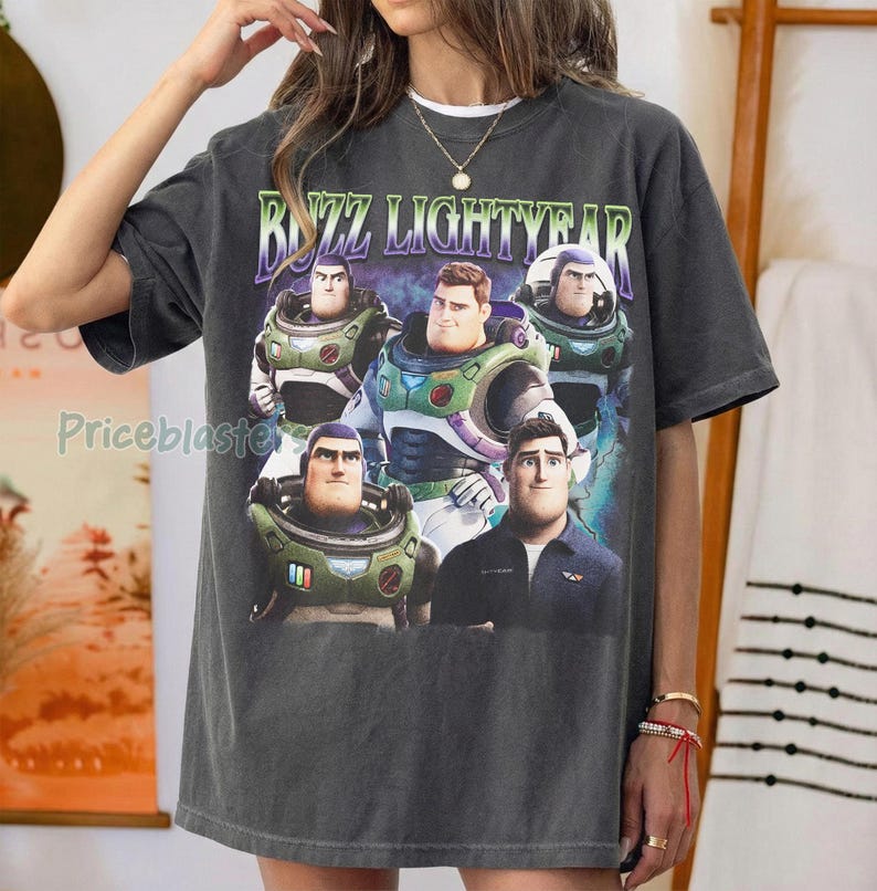 May include: Dark gray Buzz Lightyear graphic t-shirt. The shirt features a colorful graphic of Buzz Lightyear and the text "Buzz Lightyear" in a green and purple font. The shirt is a relaxed fit.