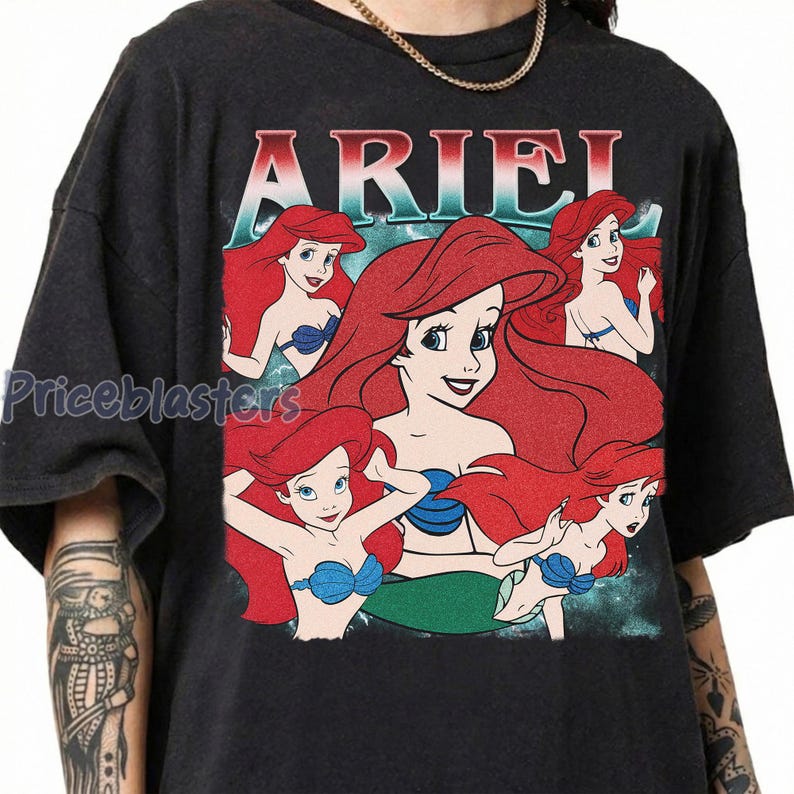 Pu&ograve; includere: T-shirt grigio scuro con la scritta "ARIEL" in rosso e blu. La maglietta presenta diverse illustrazioni di una sirena dai capelli rossi con un reggiseno a conchiglia blu. Il design ha un aspetto vintage e usurato.