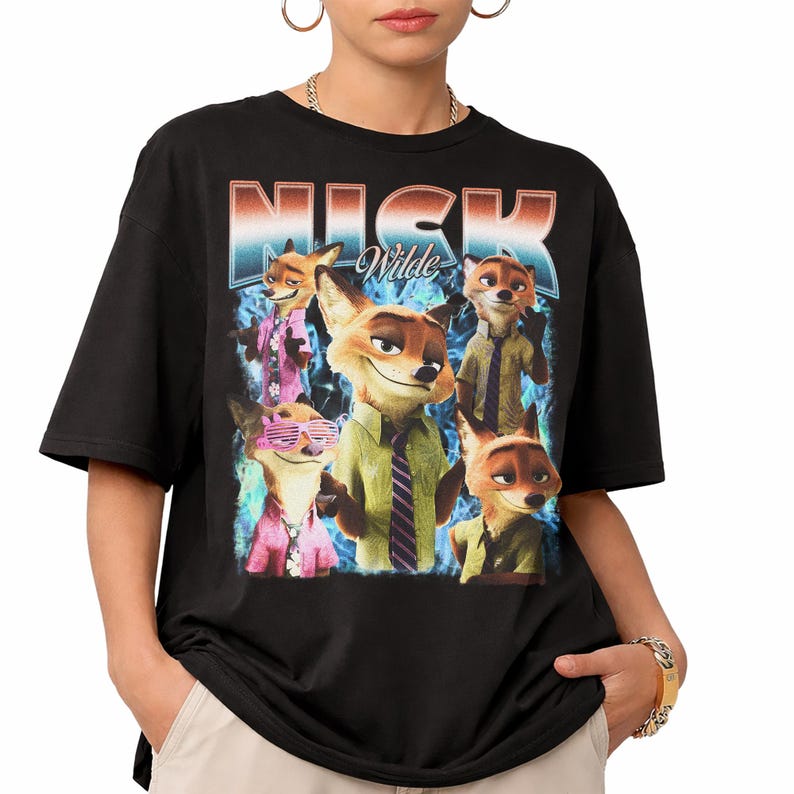 Pode incluir: Camiseta preta com um gr&aacute;fico de Nick Wilde de Zootopia. O design inclui v&aacute;rias imagens do personagem em v&aacute;rias roupas, com o nome "NICK Wilde" em uma fonte retr&ocirc;. O fundo tem um efeito esfuma&ccedil;ado azul e branco.