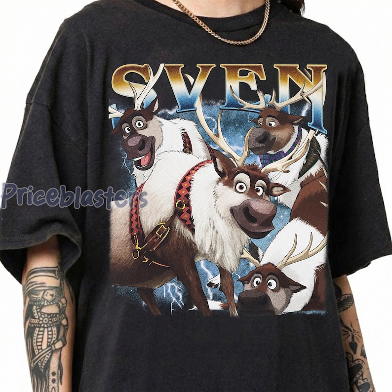 May include: Dark gray t-shirt featuring a graphic of the reindeer Sven from the movie Frozen. The design includes the word "SVEN" in gold lettering above the reindeer, with a blue and white background and lightning bolts.