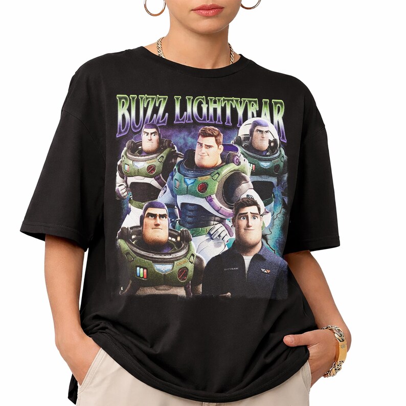 May include: Black t-shirt featuring a graphic of Buzz Lightyear and the text "BUZZ LIGHTYEAR" in a green and purple font. The graphic shows multiple images of Buzz Lightyear in different poses. The shirt is a crew neck and has short sleeves.