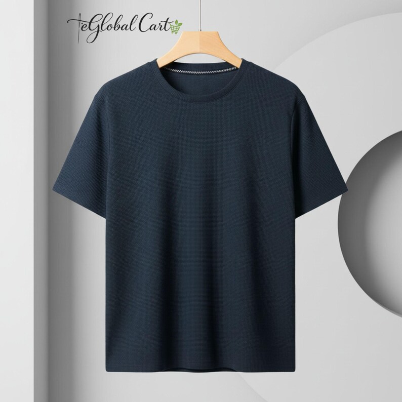 May include: A navy blue short-sleeve t-shirt with a textured pattern. The shirt has a crew neck and is hanging on a wooden hanger. The Global Cart logo is visible in the upper left corner.
