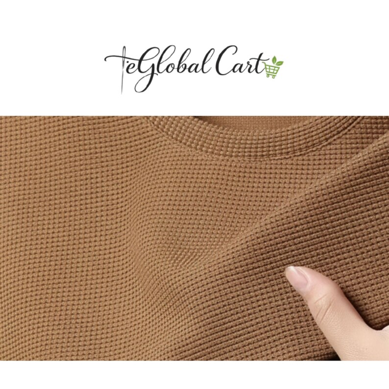 May include: Close-up of a brown waffle-knit fabric. The texture of the fabric is visible, with a grid-like pattern. The fabric is being touched by a person's finger. The top of the image has the text "eGlobal Cart".