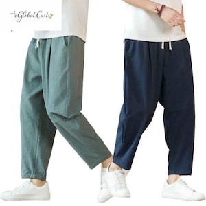 May include: Two pairs of casual linen pants in the image. One pair is a muted teal color, and the other is a deep navy blue. Both have a drawstring waist and pockets. The pants are paired with white sneakers. The logo "teGlobal Cart" is in the top left corner.
