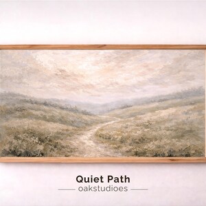 Puede incluir: Pintura de paisaje titulada "Quiet Path" en un marco de madera clara. La obra representa un camino sinuoso a través de colinas y campos, con una paleta de colores suaves de verdes, beiges y grises. El cielo está nublado, creando una atmósfera serena.