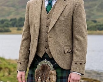 May include: A tan tweed blazer and matching waistcoat worn over a white collared shirt with a green plaid tie. A green, blue, and black tartan kilt is paired with a fur sporran featuring three tassels and tan wool socks.