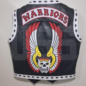 May include: A black leather vest featuring a white trim with black diamond shapes. The back displays a large embroidered patch with the word WARRIORS in red letters above a winged skull graphic with yellow, red, and white details.
