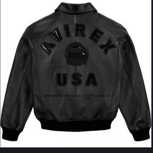 May include: Black leather bomber jacket with the word "AVIREX" arched across the upper back, above a circular emblem and the word "USA". The jacket has a ribbed collar, cuffs, and hem. The jacket is a classic style.