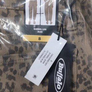 May include: Tan denim jeans with a dark brown leopard print pattern. The jeans feature a Buffalo Jeans brand tag with the text BARREL LEG JEAN and size 8. A secondary white tag displays the text 199269081261 BARREL JEAN LEOPARD AOP SLC0060US.