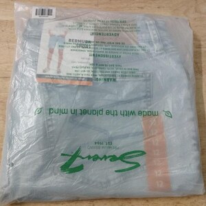 May include: Light blue denim shorts packaged in a clear plastic bag. The packaging features the Seven7 Premium Brand logo, a size 12 label, and a graphic showing the shorts being worn. The plastic bag includes safety warnings and environmental text.
