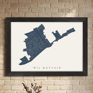 Może przedstawiać: Oprawiony wydruk mapy Wij Mayfair w kolorze granatowym. Mapa jest umieszczona na kremowym tle, z tekstem "WIJ MAYFAIR" na dole. Rama jest czarna, a wydruk wisi na ceglanej ścianie.