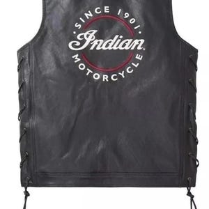 Könnte beinhalten: Schwarze Motorradweste aus Leder mit dem Logo "Indian Motorcycle" auf dem Rücken. Das Logo ist in einem kreisförmigen Design mit roter und weißer Schrift gehalten. Die Weste hat seitliche Schnürungen und ein ärmelloses Design.