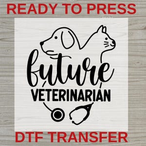 May include: A black DTF heat transfer design featuring a line art illustration of a dog and a cat positioned above the text future VETERINARIAN, with a stethoscope graphic below the text. The design is presented on a white square background.