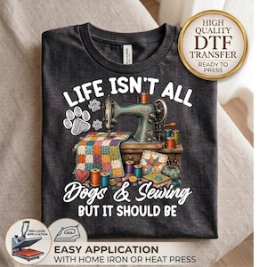 May include: A dark gray t-shirt featuring a graphic of a vintage sewing machine, a colorful patchwork quilt, and spools of thread. The text reads: LIFE ISN'T ALL DOGS & SEWING BUT IT SHOULD BE. A gold circular badge in the corner says HIGH QUALITY DTF TRANSFER.