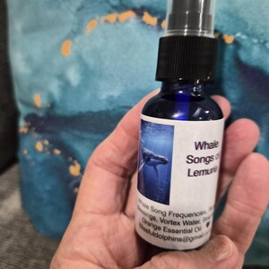 Peut inclure: Un petit flacon pulvérisateur en verre bleu avec une pompe noire et une étiquette blanche. L'étiquette présente une image de baleine et le texte Whale Songs of Lemuria, Whale Song Frequencies, Blessings, Vortex Water, Brazilian Orange Essential Oil.
