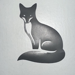 Può includere: Silhouette stilizzata di una volpe seduta, di colore grigio scuro con petto e ventre bianchi. Il design è semplice ed elegante, adatto a vari usi.