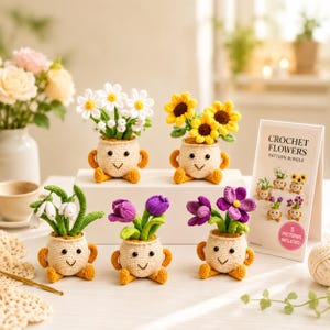 Puede incluir: Cinco macetas de ganchillo con caras sonrientes, cada una con diferentes flores de hilo, incluyendo margaritas blancas, girasoles amarillos, campanillas blancas, tulipanes morados y azafranes morados, junto a una tarjeta de patrones.
