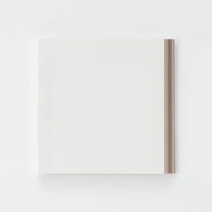 Könnte beinhalten: Ein quadratischer weißer Notizblock mit einem Stapel Papierblätter. Die rechte Kante des Notizblocks zeigt einen vertikalen Streifen aus mehrfarbigen Papierkanten, die dünne Schichten verschiedener Farben wie Braun-, Blau- und Grautöne aufweisen.