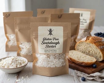 Puede incluir: Varias bolsas de papel marrón con copos blancos secos, etiquetadas Gluten-Free Sourdough Starter Artisan Dried Flakes Naturally Leavened. Un cuenco con copos está cerca, junto a una hogaza de pan rebanada sobre una tabla de madera.