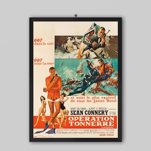May include: Framed vintage movie poster for "Operation Thunderball" featuring Sean Connery. The poster has a black frame and displays colorful illustrations of action scenes, including underwater combat and a man with a gun.