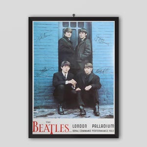 May include: A framed poster featuring The Beatles. The image shows the band members in black suits, posing in front of a blue brick wall. The poster includes the band's name and the words "London Palladium Royal Command Performance 1963."