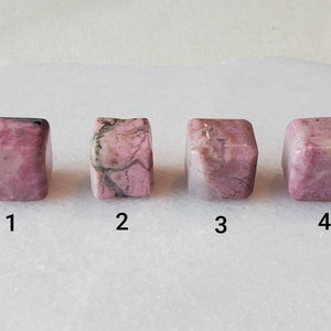 May include: Four pink and white cubes of polished rhodochrosite, numbered 1 through 4.