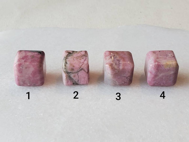 May include: Four pink and white cubes of polished rhodochrosite, numbered 1 through 4.