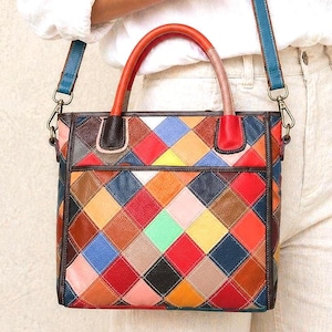 May include: A rectangular handbag featuring a multi-coloured patchwork design of diamond-shaped leather pieces in red, blue, yellow, green, pink, brown, and black. It includes two top handles, a detachable blue shoulder strap, and dark trim.