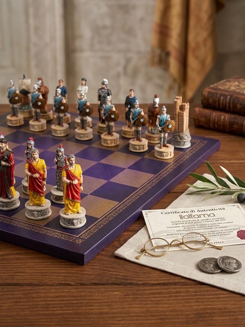 May include: A chess set featuring hand-painted Roman-themed pieces on a purple and gold chequered board. The set includes a certificate of authenticity from Italfama, a pair of gold-rimmed spectacles, and two metal coins resting on a linen cloth.