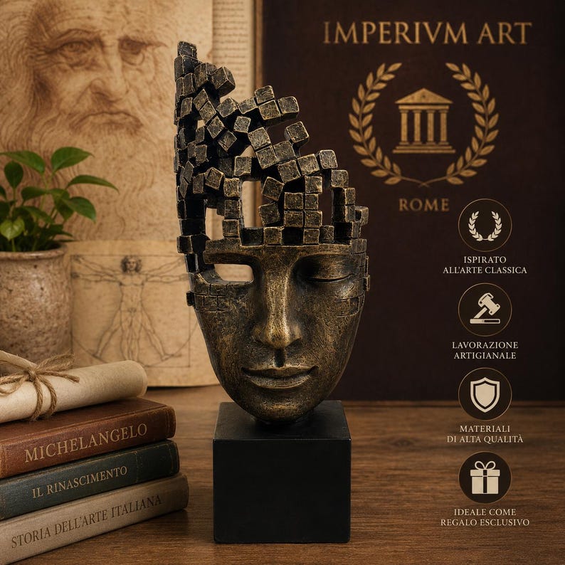 May include: A bronze-colored sculpture of a face with a fragmented top, mounted on a black square base. The sculpture has closed eyes and a serene expression. The background includes books and the text "IMPERIVM ART ROME".