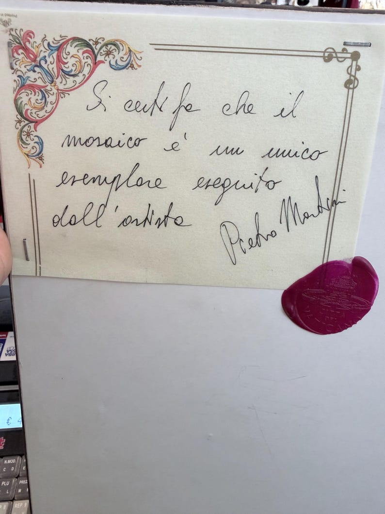 Pu&ograve; includere: Un certificato di autenticit&agrave; rettangolare con un decoro floreale nell'angolo in rosso, blu e verde. Presenta testo scritto a mano in italiano e una firma di Pietro Martini, rifinito con un sigillo in ceralacca magenta circolare nell'angolo.