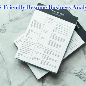 May include: Two resume templates with the text "ATS Friendly Resume Business Analyst CV" in blue. The resumes are white with black accents and include sections for contact information, skills, and experience. The resumes are stacked on a marble surface.