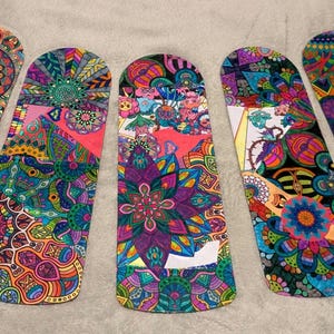 May include: Five colorful, patterned decorative items with a rounded top and a flat bottom. Each item features a unique, intricate design with a variety of colors including blue, green, purple, and orange. The designs appear to be inspired by mandalas and floral patterns.