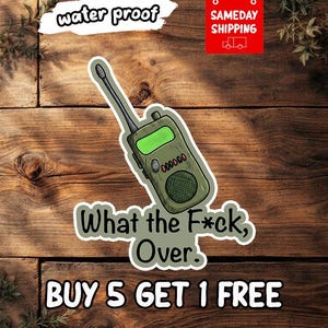 May include: A die-cut sticker featuring an olive green walkie-talkie with a black antenna, a bright green screen, and a speaker grille. Below the device, the text reads "What the F*ck, Over." The sticker has a white border and a matte finish.